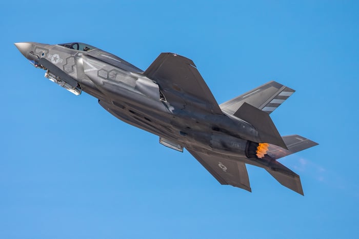 A military airplane flies in the sky. 