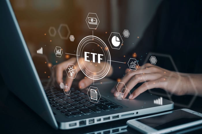 A person searching for ETFs on a laptop.