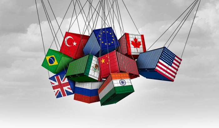 A shipping container with a U.S. flag on it rams into shipping containers from other countries. 
