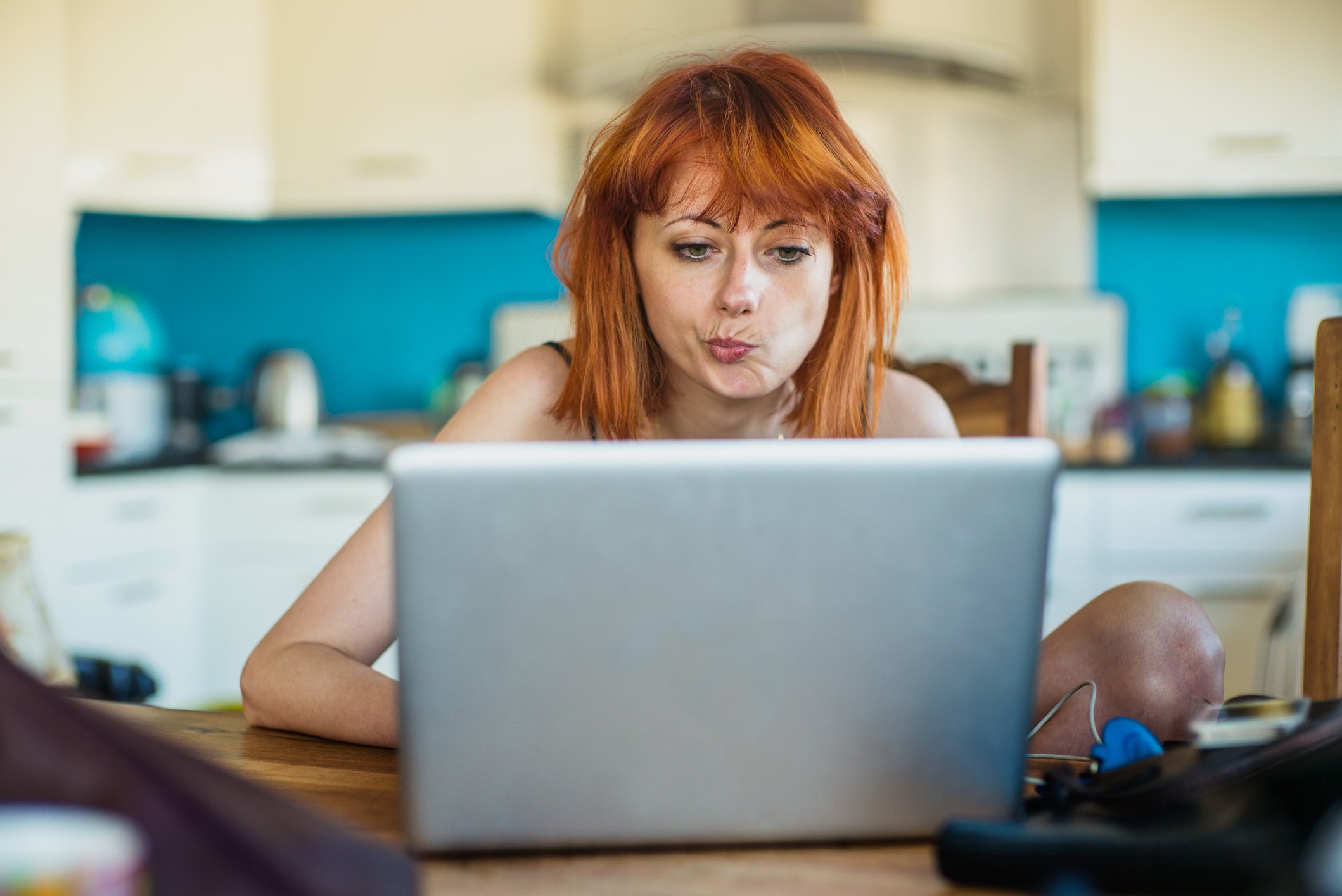 Woman looking at laptop and thinking