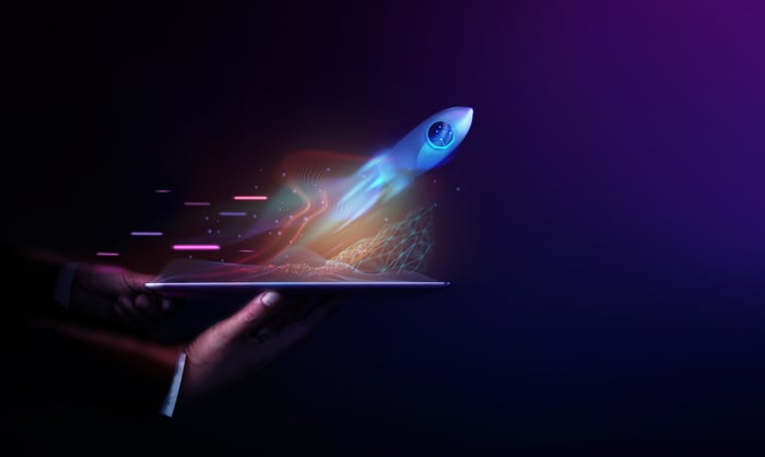 Artist rendering of a rocket launched off a tablet held in a person's hand