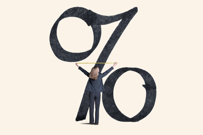 A person measuring a larger percent sign.