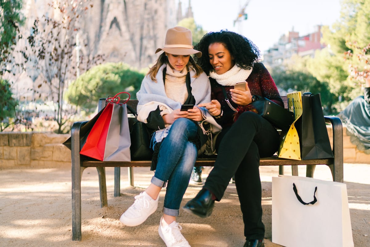 2 people with shopping bags and cellphones