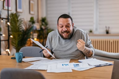 26_07_15 A person sitting with papers and an excited look of discover _GettyImages-1497188924-1200x800-5b2df79