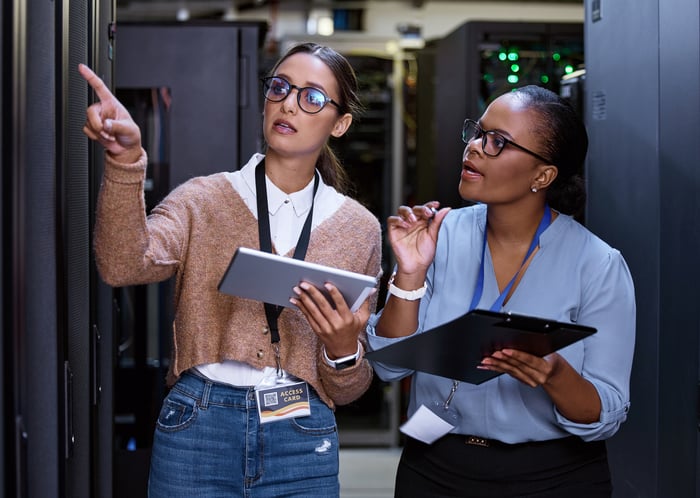 Two people checking in on a data center.