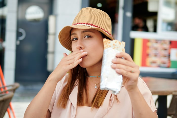 Person eating a burrito.