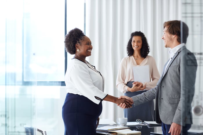 People shaking hands in an office.
