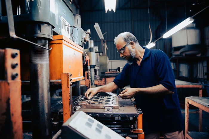 A factory worker is working machinery on an assembly line.