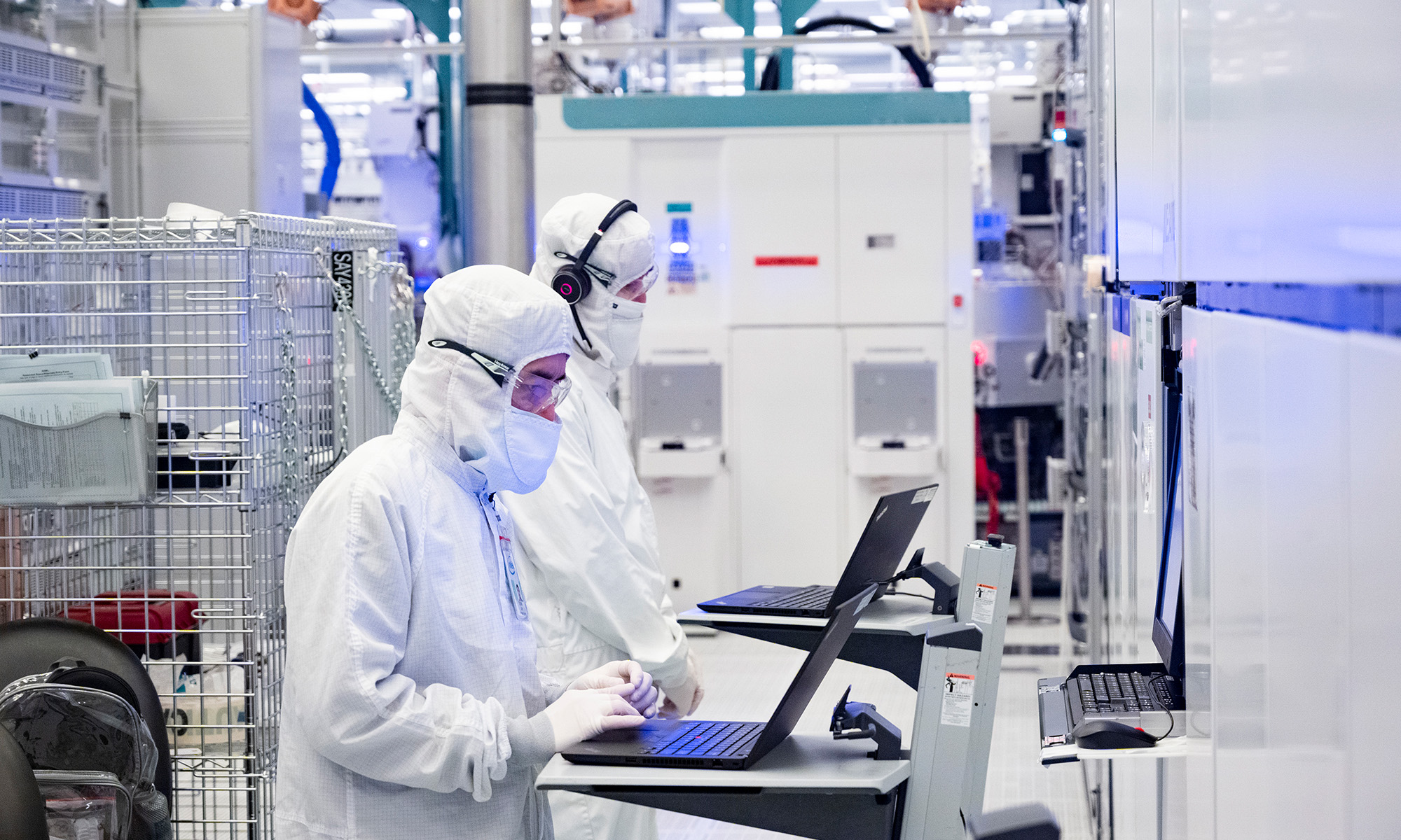 inside intel factory two people working on laptop with lab gear on_Intel