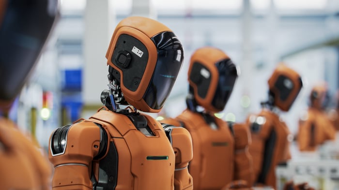 A row of robots works in a factory. 