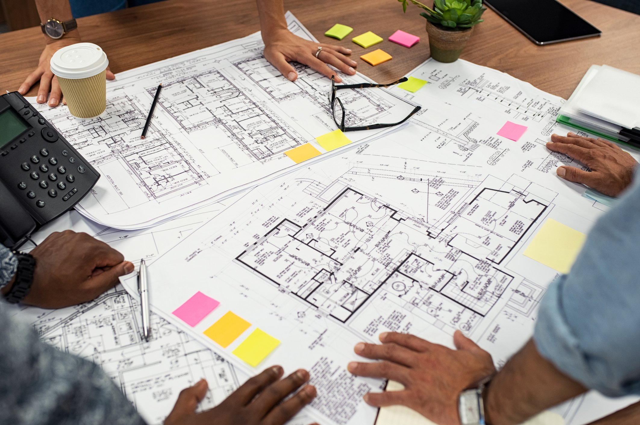 Workers spread out blueprints on a table