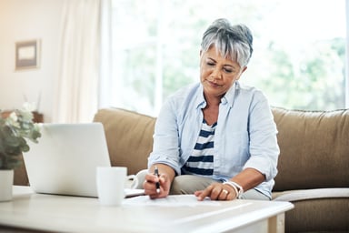 Older woman laptop holding pen GettyImages-902863756