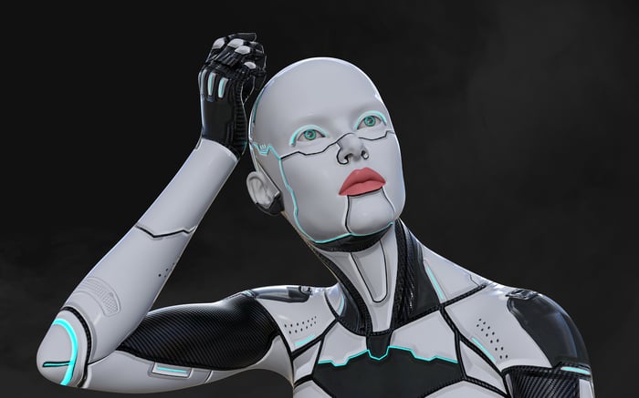 A humanoid robot scratching its white, shiny head.
