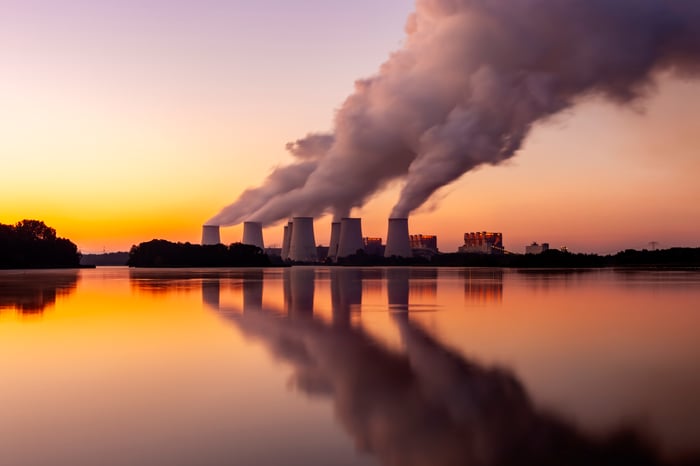 A nuclear plant sits across a lake at sunset. 