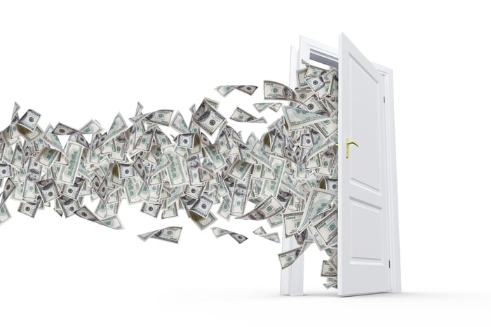 Cash flowing out of an open door.