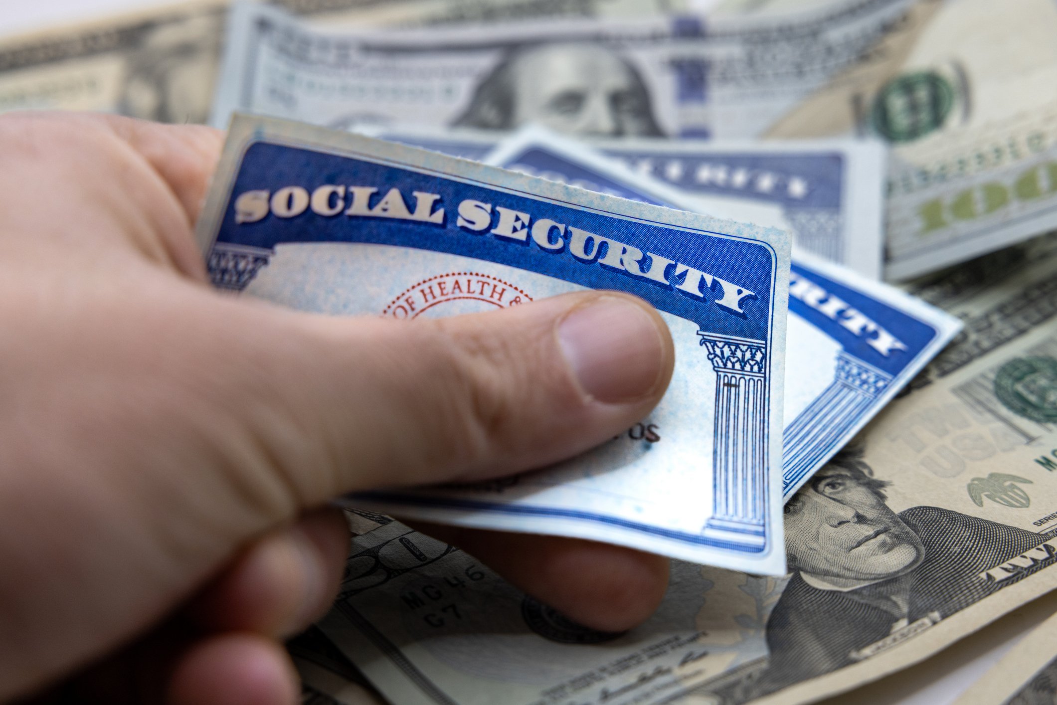 Getty - hand holding social security card income retirement