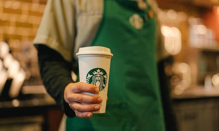 A person holding a Starbucks cup.