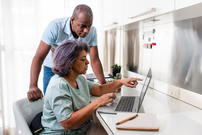 Retired couple working together on a laptop. 