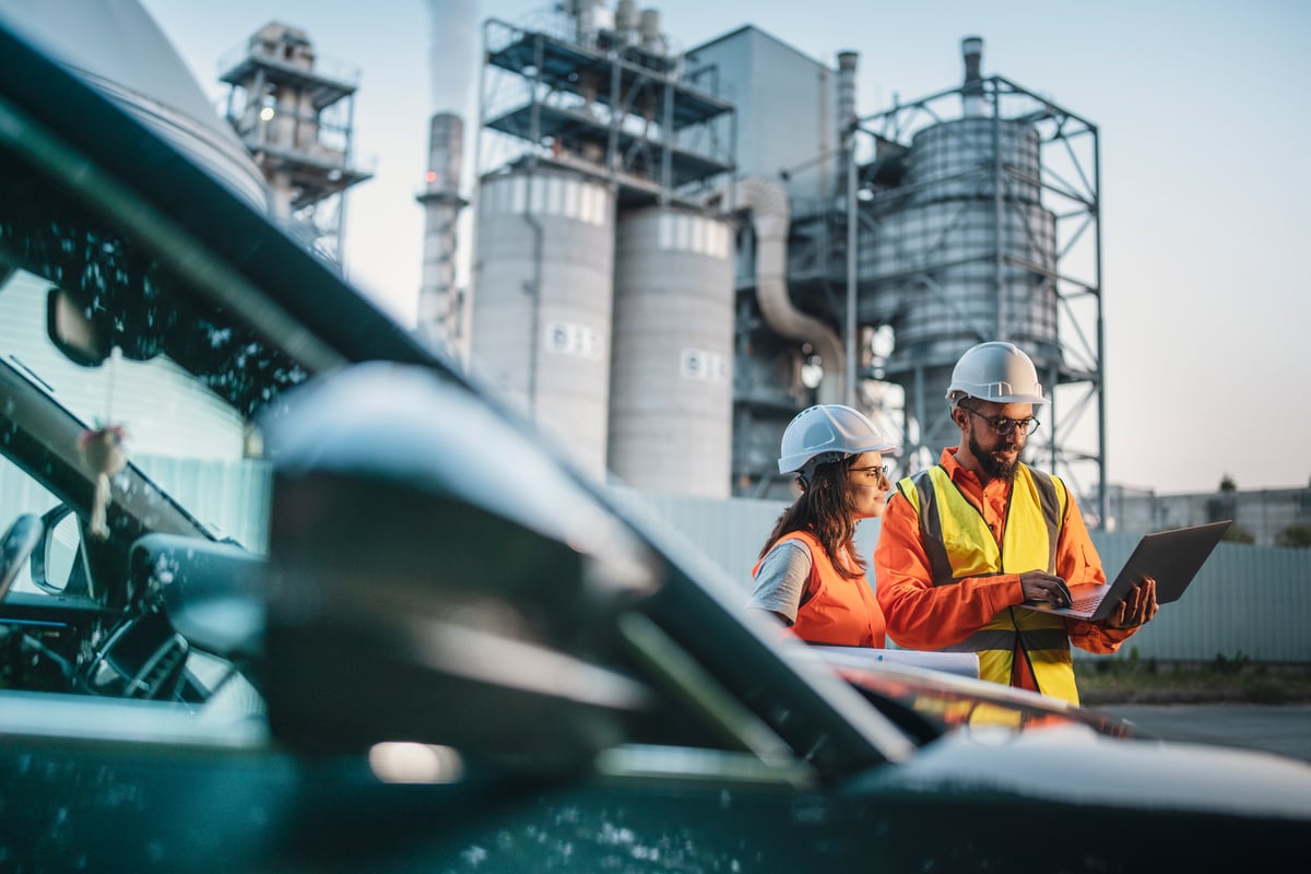 engineers work on laptop outside of nuclear power station.