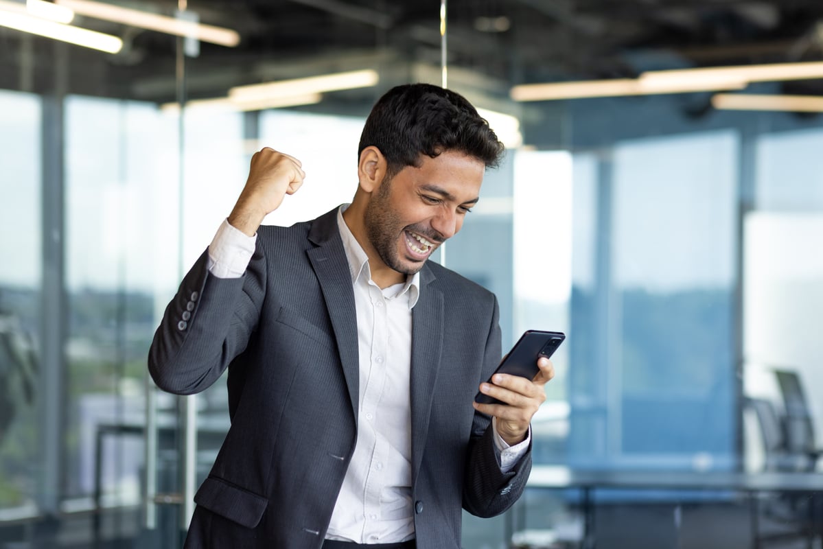 excited happy person waving fist and looking at phone