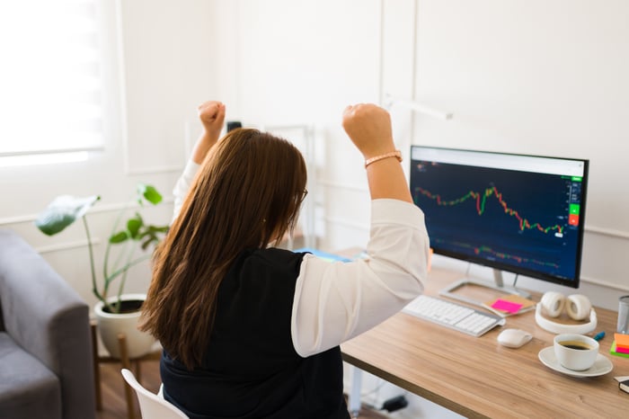 Happy investor watching computer screen.