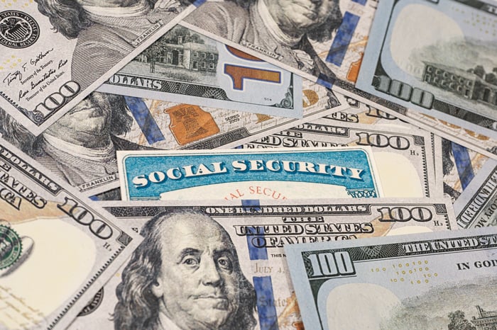 A Social Security card in a pile of $100 bills.