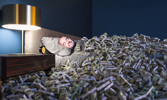 A 401(k) millionaire is sleeping surrounded by money.