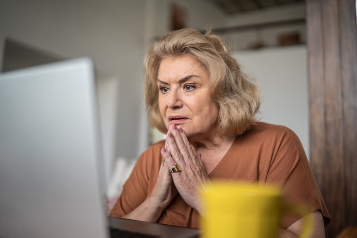 Worried person looking at laptop.