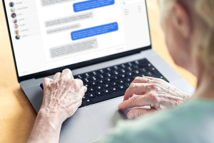 An individual types texts on a laptop.