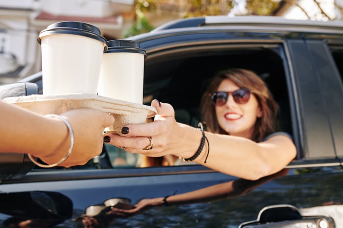 A person buying coffee at a drive thru.