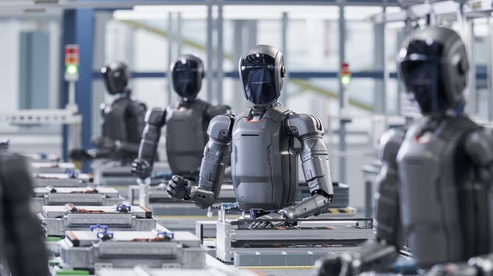 A line of humanoid robots at work in a factory.