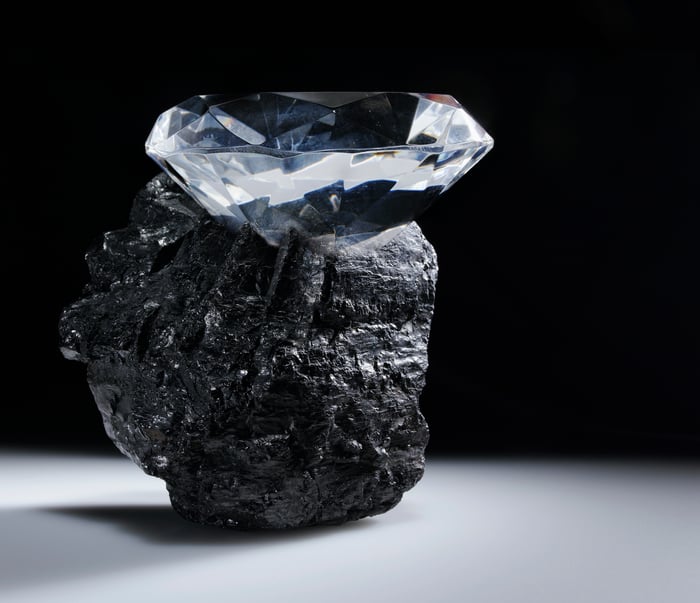 A diamond sits in a piece of coal.