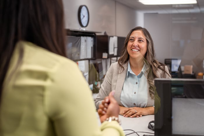 People sitting at a desk making a deal.