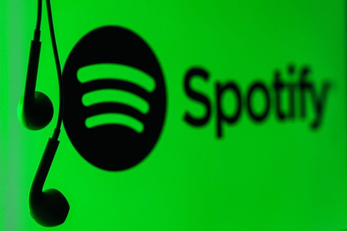 Spotify logo next to hanging earbuds.