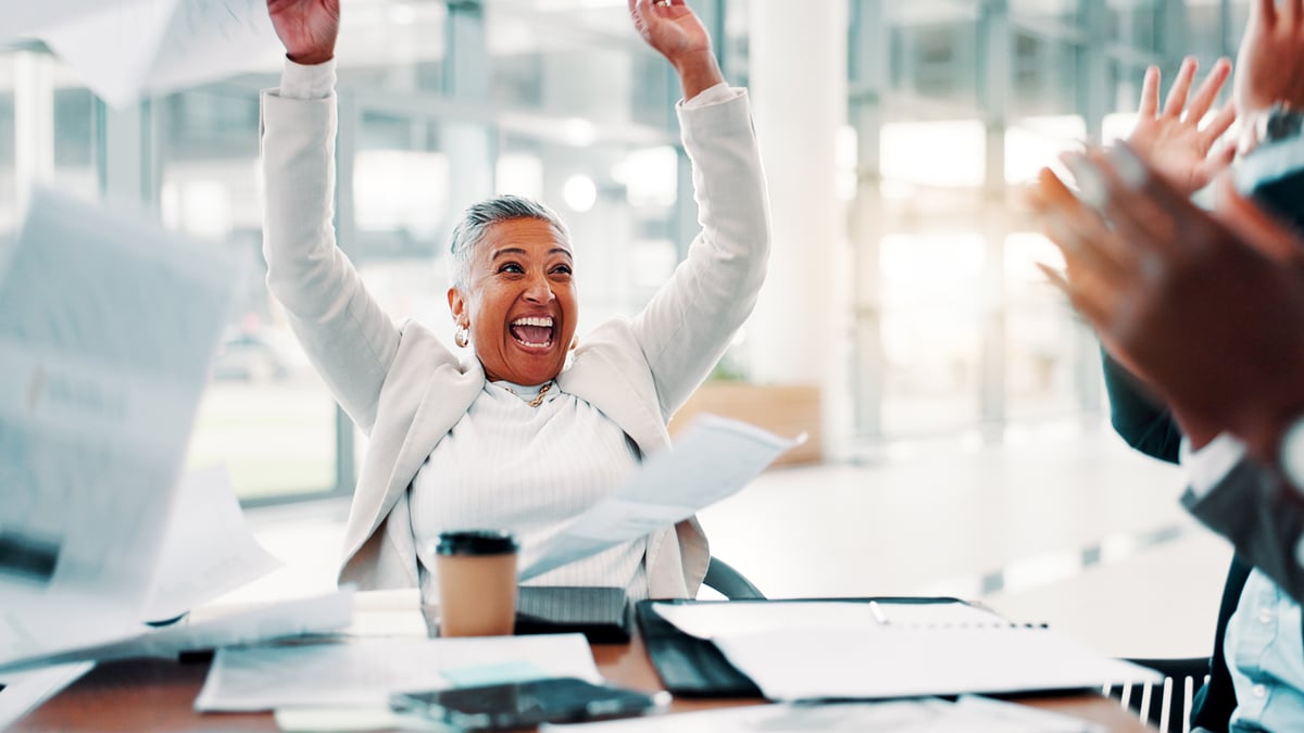 happy investor celebrates at a conference table.