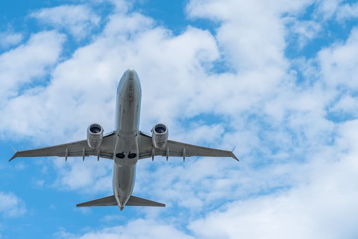 A jet airliner soaring amid blue sky and clouds.
