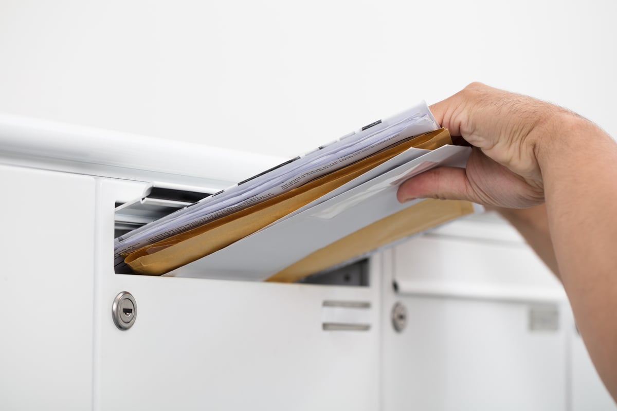 putting mail in a mail slot at a post office-1200x800-5b2df79