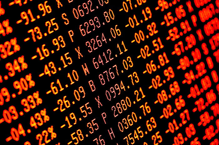 A stock market video board showing stocks all in the red and negative. 