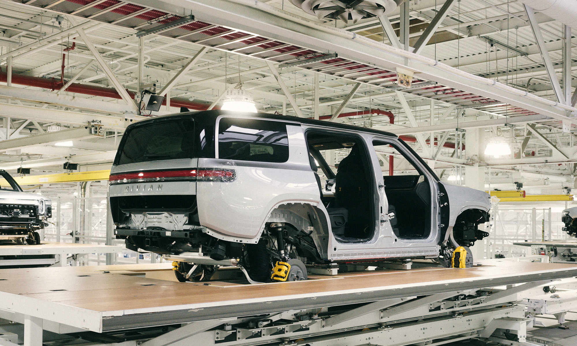 suv on assembly line with _rivian badge logo_rivian_