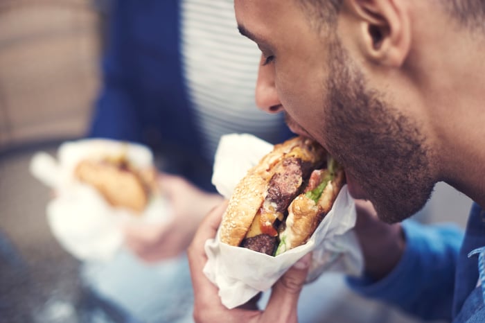 Person eating a hamburger.