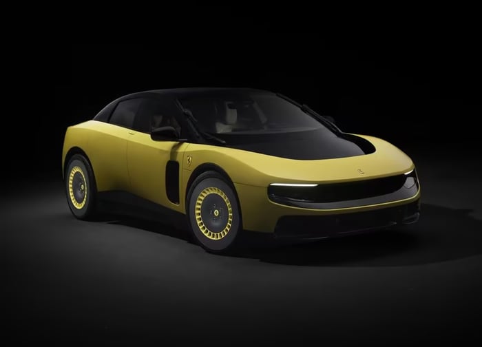 A yellow Luce, Ferrari's first full-electric vehicle, against a black background.