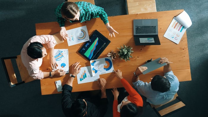 People reviewing reports at a meeting.