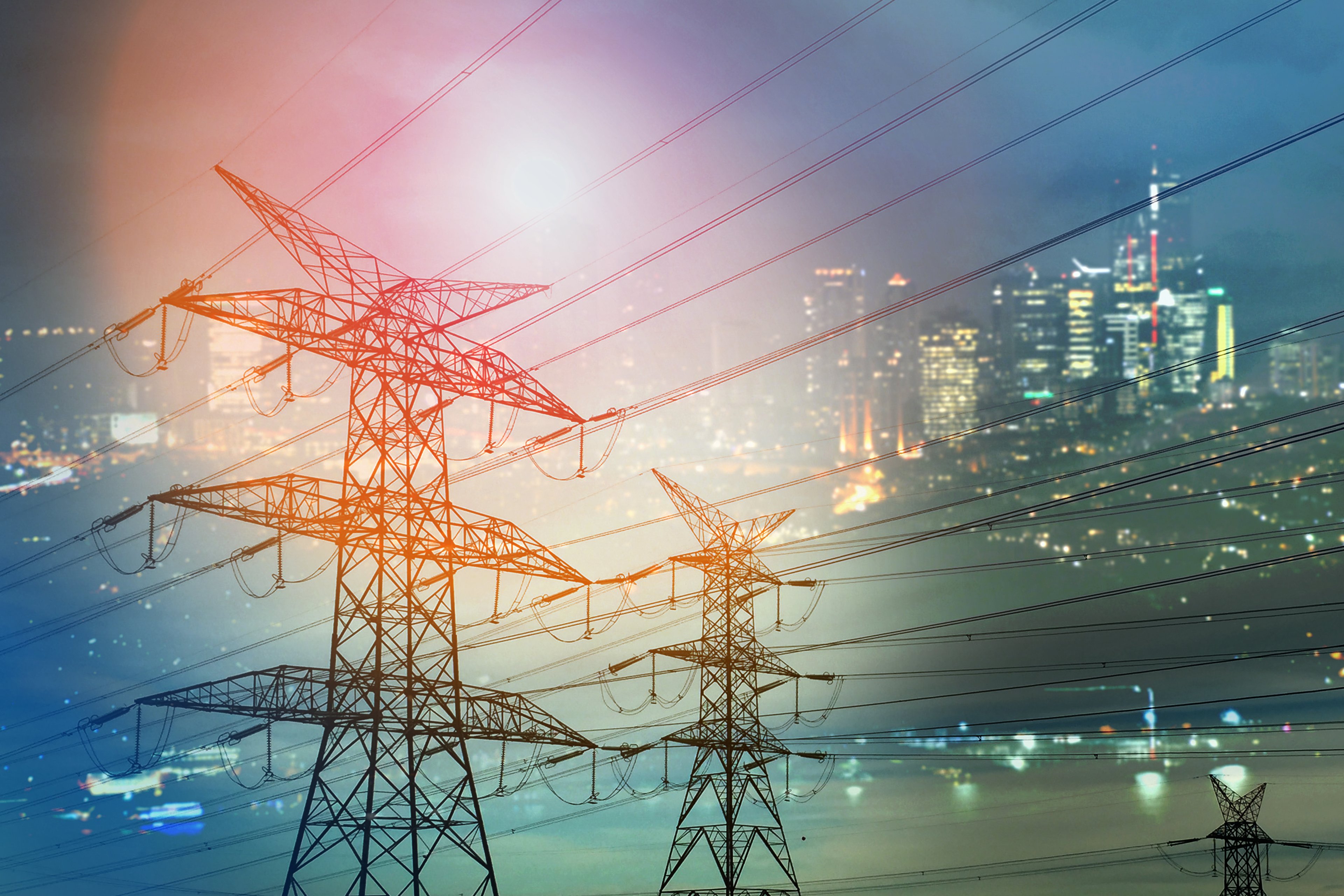 high voltage transformers with night city lights in background getty