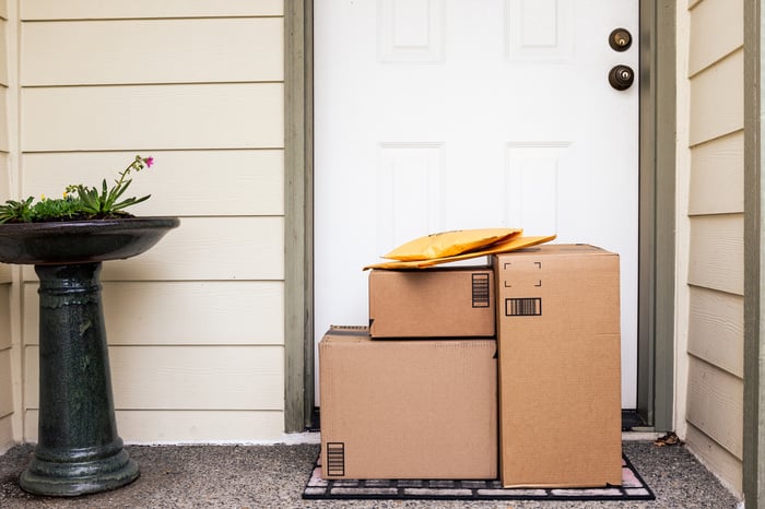 Amazon packages neatly stacked in front of a homeowner's door.