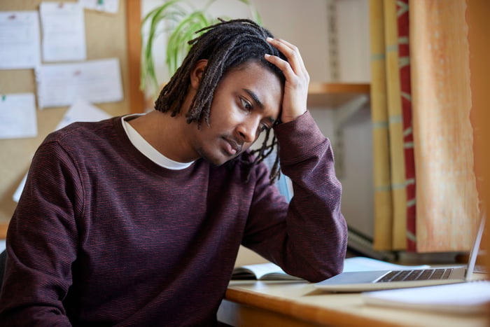 sad investor works on laptop.