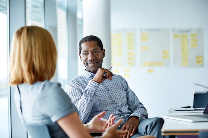 Two professionals talking with each other in the office.