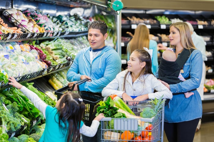 People shopping in the produce aisle.