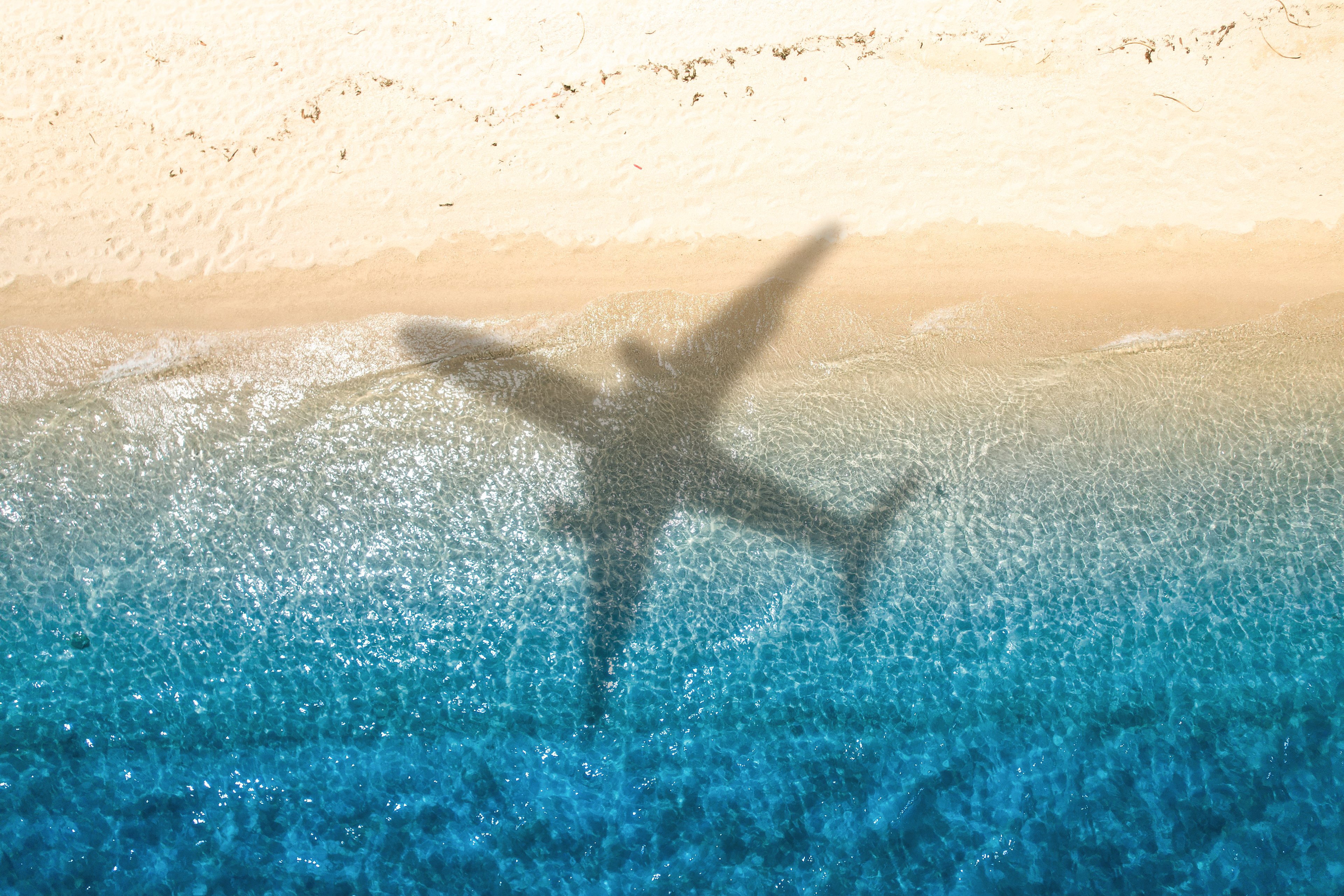 airplane shadow beach vacation Getty Images