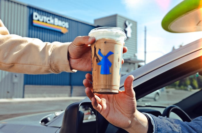 A Dutch Bros beverage being handed to a customer.