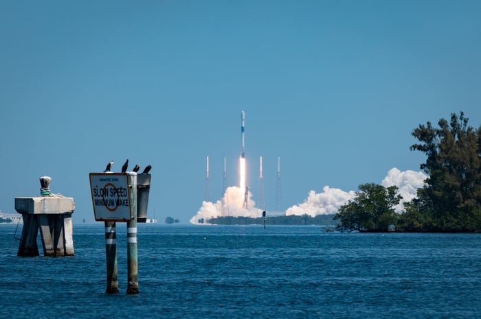 A rocket launching in distance over open ocean.